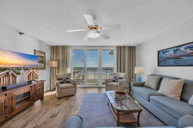 Living room featuring visible vents, a textured ceiling, ceiling fan, and wood finished floors