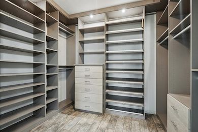 With custom shelving, cabinetry and lighting, the upgraded primary closet provides ample storage for all your needs.