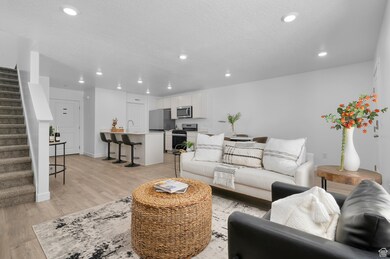 Living room featuring stairs, light wood-style flooring, recessed lighting, and a textured ceiling