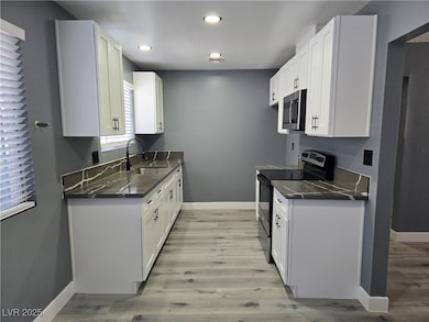 Kitchen with stainless steel microwave, baseboards