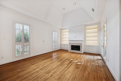 The airy formal living room is situated to the left of the front door is the perfect place to greet your guests. Off the living room is a gorgeous wet bar, perfect for entertaining! Also featuring lit shelves.