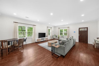 Living room featuring dark wood finished floors, recessed lighting, baseboards, and crown molding