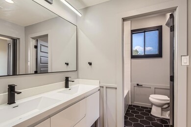 Bathroom with toilet, double vanity, tile pattern