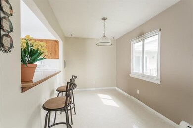 Bright and airy dining area opens into kitchen wit