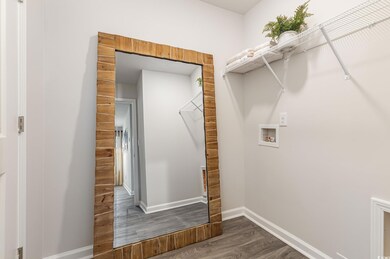 Laundry room featuring hookup for a washing machine, dark wood-style flooring, and baseboards
