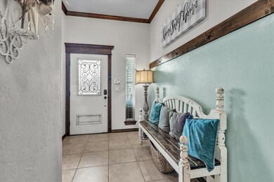 Tiled foyer entrance featuring crown molding