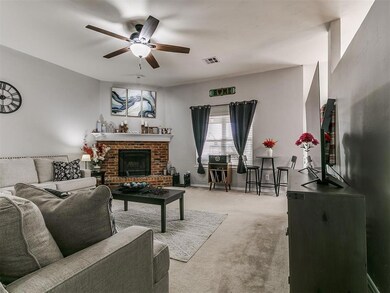 Living room with visible vents, a brick fireplace,