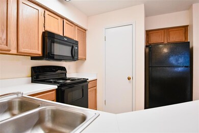 Kitchen with black appliances, a sink, light coun