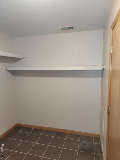 Walk in closet featuring dark tile patterned flooring