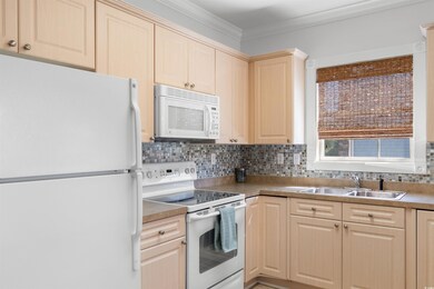 Kitchen with white appliances, light brown cabinet