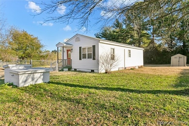 View of property exterior featuring a lawn and a s