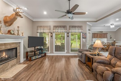 Living room with crown molding, a tiled fireplace,