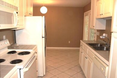 Kitchen featuring a sink, white appliances, light