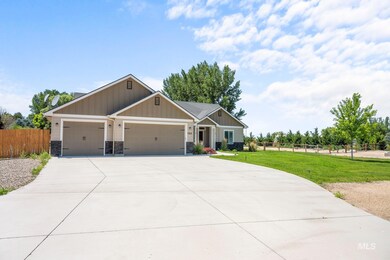 Craftsman-style house with a garage, driveway, board and batten siding, and stone siding