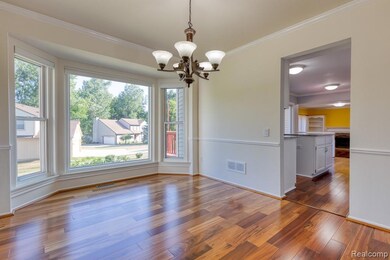 Unfurnished dining area with ornamental molding, dark wood-style flooring, and a chandelier