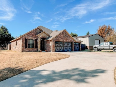 View of front of property with brick siding, concrete driveway, and a shingled roof