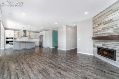 Unfurnished living room featuring sink, a tile fir