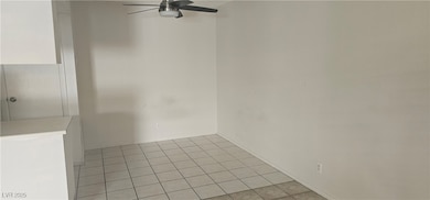 Unfurnished room with light tile patterned floors and a ceiling fan