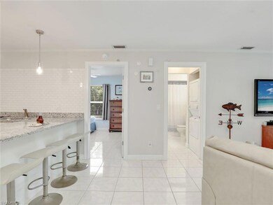 Kitchen with hanging light fixtures, light stone c