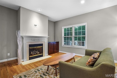 Gas fireplace flanked by a built-in cabinet, double window overlooks the backyard