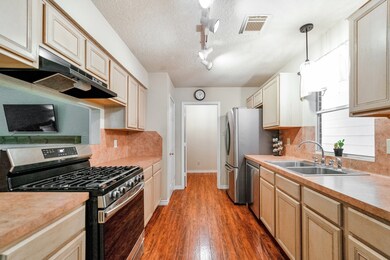 The Fridge stays! The kitchen with breakfast bar seating has two pantries; one is a large walk-in with two metro racks for additional storage.