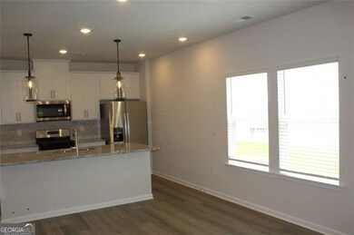 Kitchen featuring stainless steel appliances, decorative backsplash, recessed lighting, dark wood-type flooring, and pendant lighting