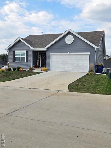 Single story home with concrete driveway, a garage, a shingled roof, and a front lawn