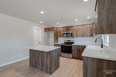 Kitchen featuring appliances with stainless steel finishes, a center island, light countertops, light wood-style floors, and recessed lighting