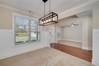 Unfurnished dining area with carpet flooring, ornamental molding, wood finished floors, and a ceiling fan