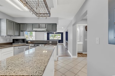 Kitchen featuring gray cabinetry, a center island,