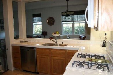 The compact kitchen overlooks the living and dinin