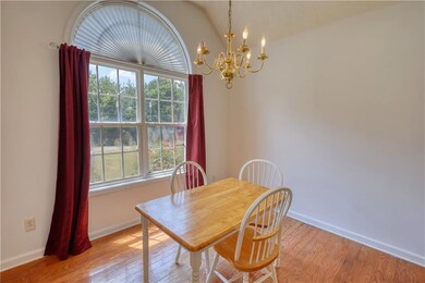 Dining area featuring plenty of natural light, a chandelier, light wood-style floors, and lofted ceiling