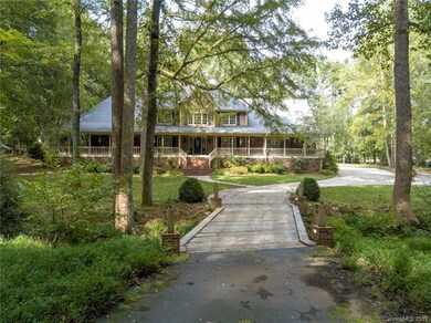 Winding asphalt drive with wooden bridge over gentle stream/creek.