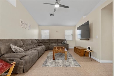 Living area with vaulted ceiling, a ceiling fan, l