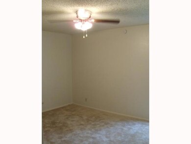 Carpeted empty room featuring a ceiling fan, a te