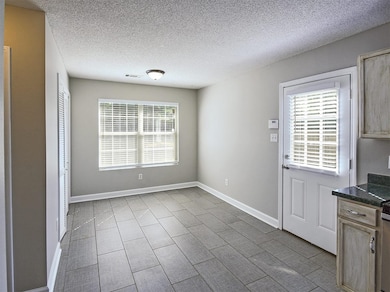 Unfurnished dining area with a textured ceiling, b
