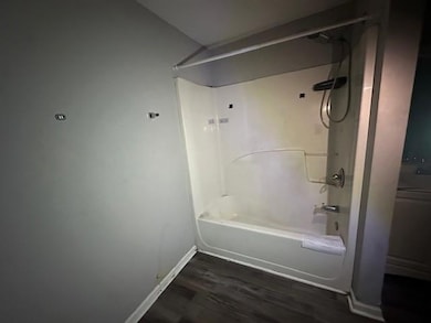 Bathroom with  shower combination and dark wood-style flooring
