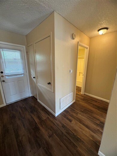 Hall with baseboards, dark wood-style flooring, a