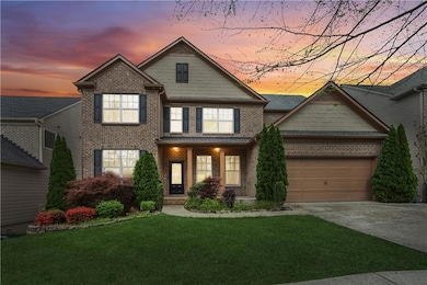 Craftsman-style house with an attached garage, concrete driveway, a front lawn, and brick siding