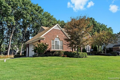 View of front of house featuring a front lawn, brick siding, and an attached garage