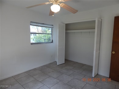 Unfurnished bedroom featuring a closet, a ceiling fan, and light tile patterned flooring