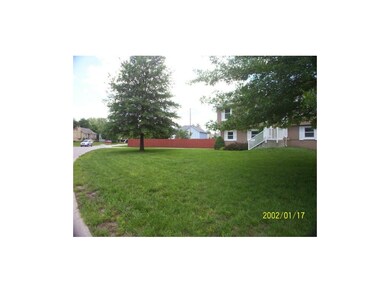Shows the expansive front lawn and curved street.