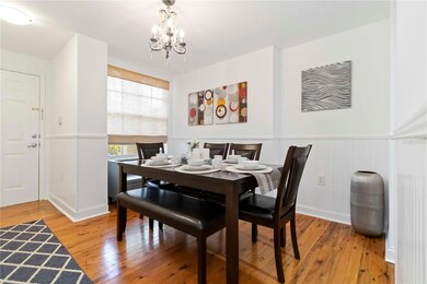 Dining area with wainscoting, wood floors, and chandelier