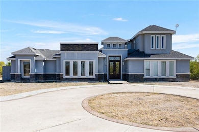 View of front of property with stone siding, a shingled roof, and stucco siding