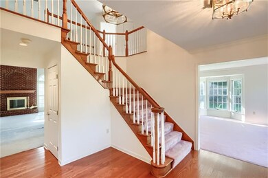 The spacious foyer is graced with hardwood floors, abundant storage, and a neutral tone.