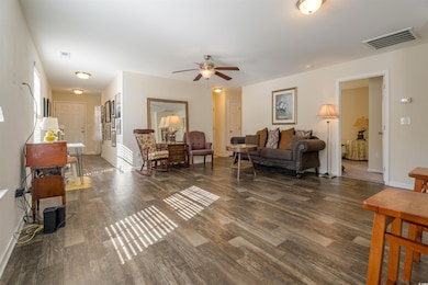 Living room featuring wood finished floors and a ceiling fan