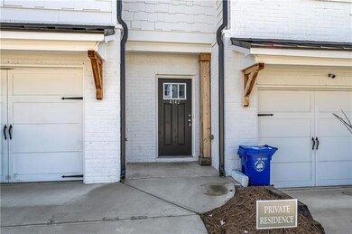 Property entrance featuring brick siding and a gar