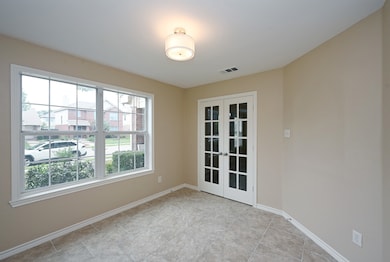 Spare room featuring french doors and baseboards