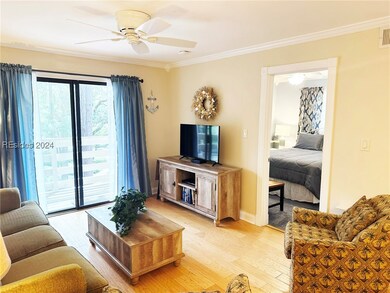 Living room featuring ceiling fan, light hardwood