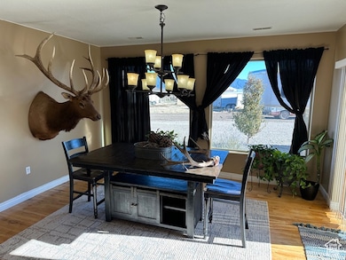Dining area featuring a healthy amount of sunlight, hardwood / wood-style flooring, and an inviting chandelier